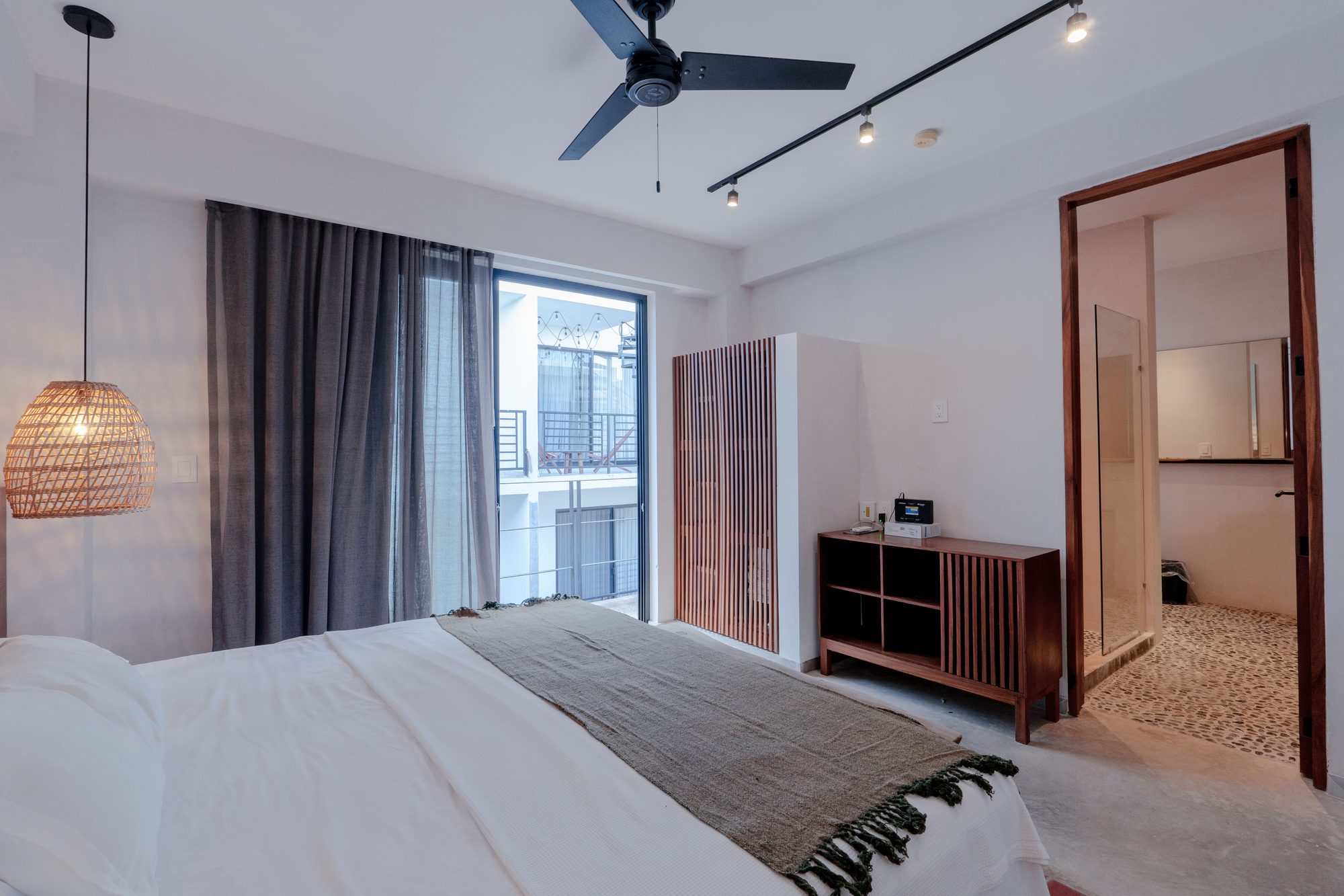 Second bedroom with a king bed, ceiling fan, dresser and doorway to the bathroom