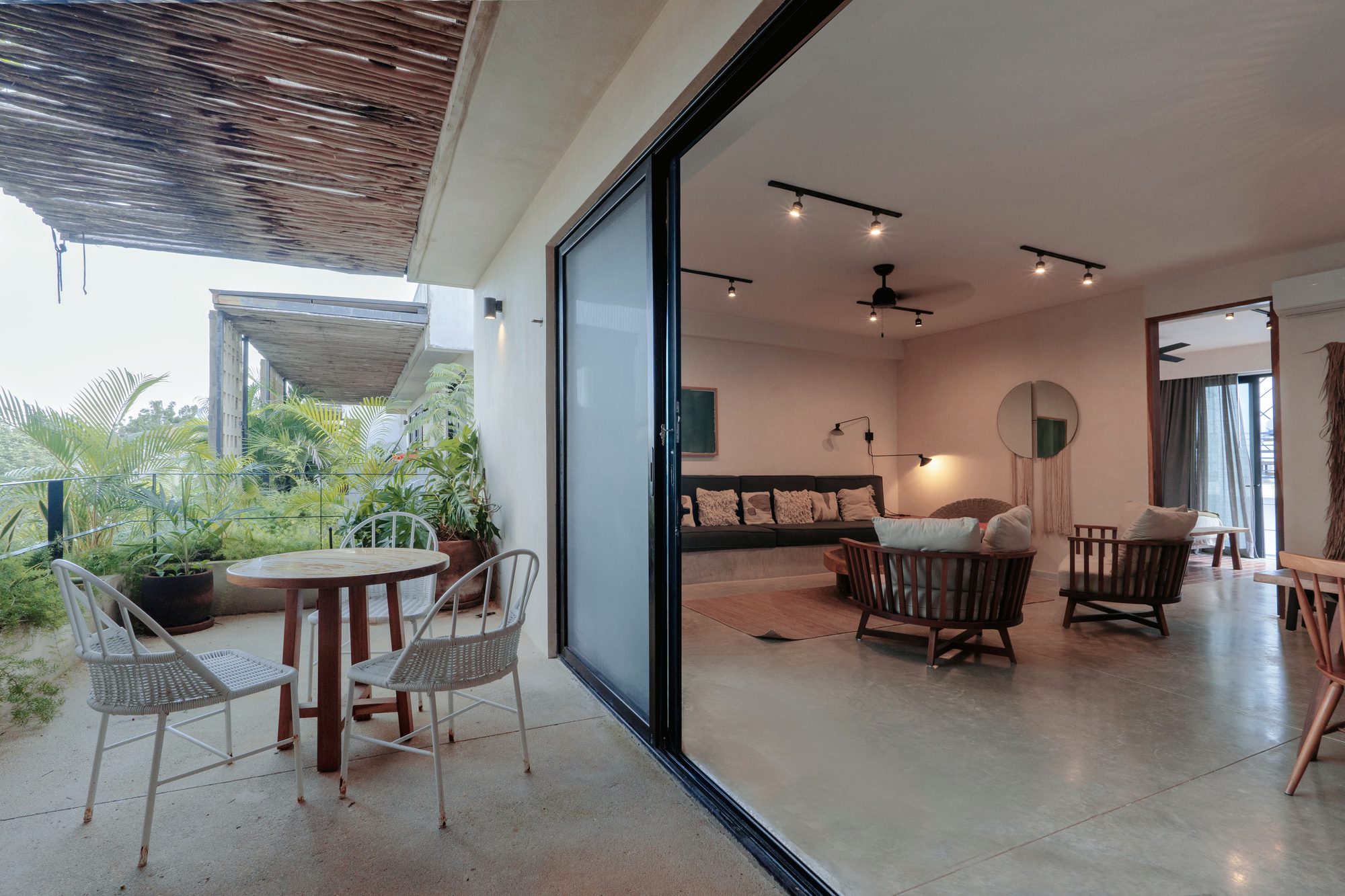 Private terrace with a round table and chairs, opening through sliding glass doors to the living room