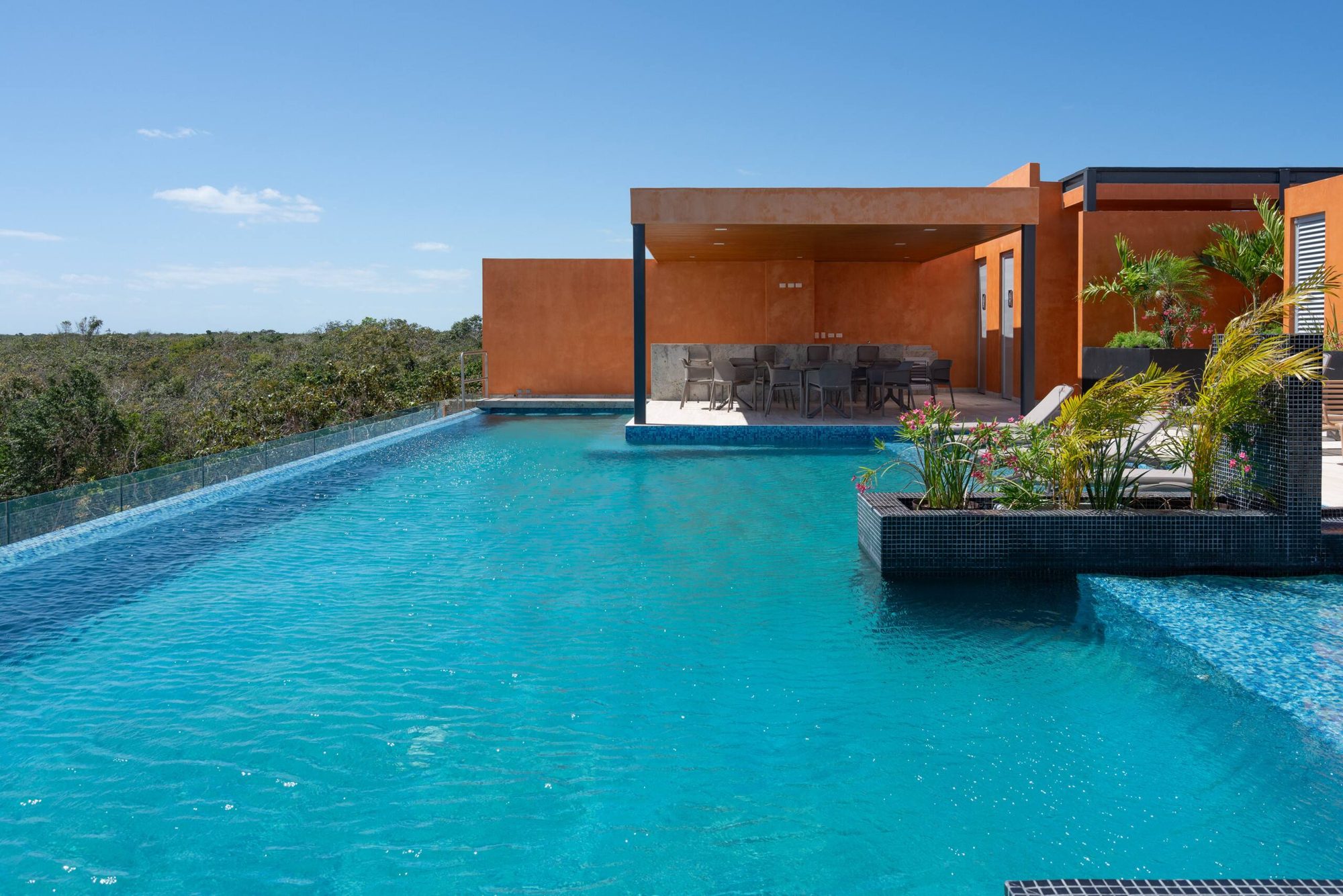 Rooftop infinity pool beside a covered lounge