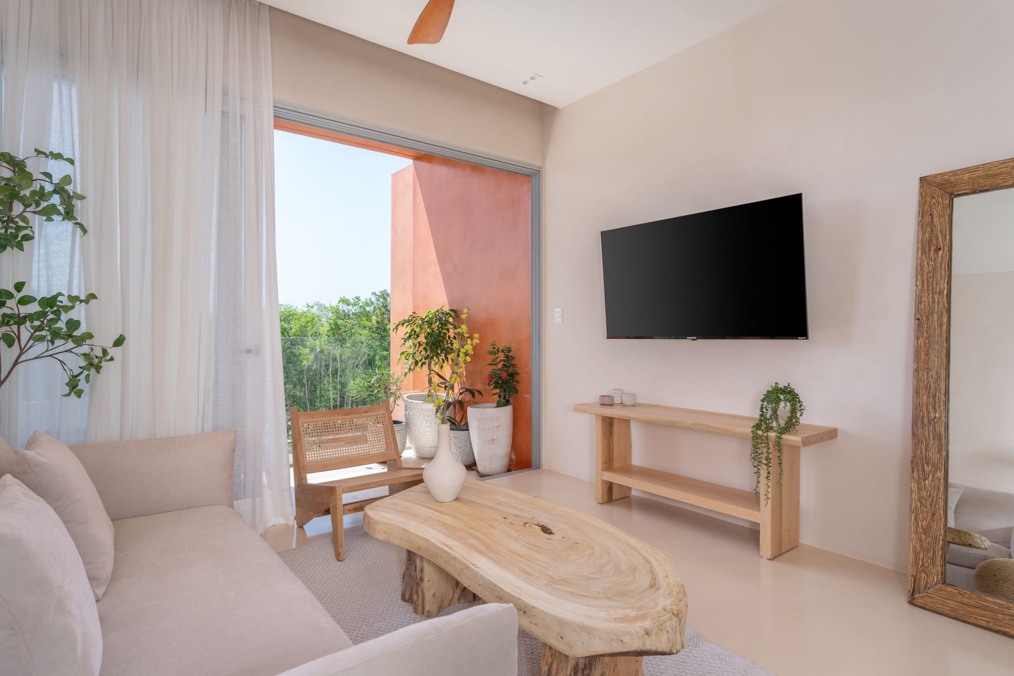 Living room with smart TV, wood console and a tall wood-framed mirror