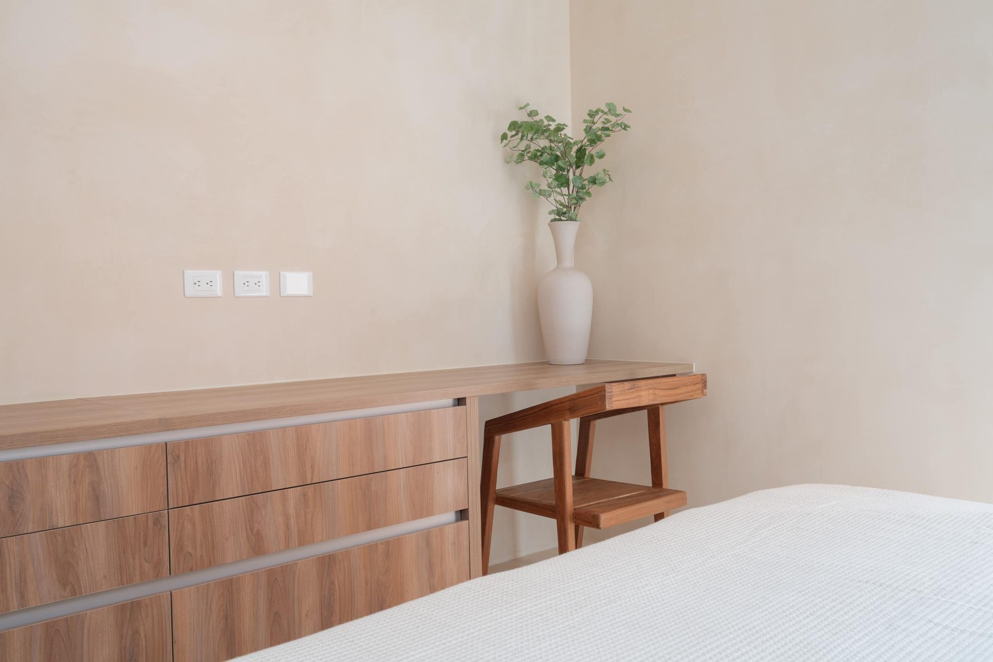 Bedroom dresser and desk with a potted plant