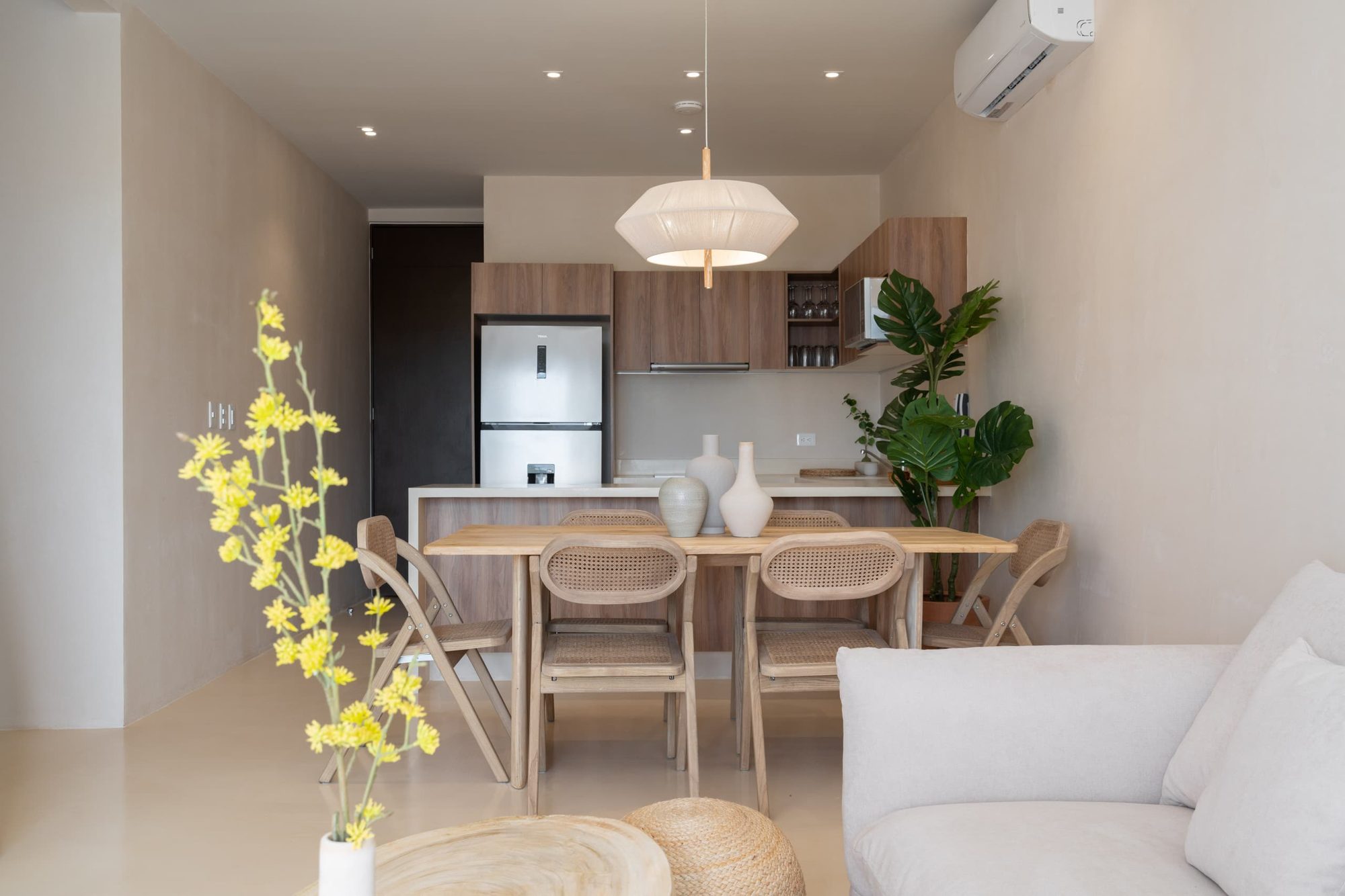 Dining table for six under a woven pendant lamp