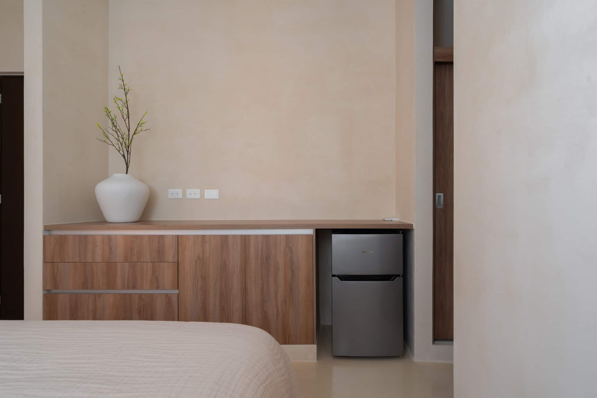 Bedroom desk area with a mini fridge