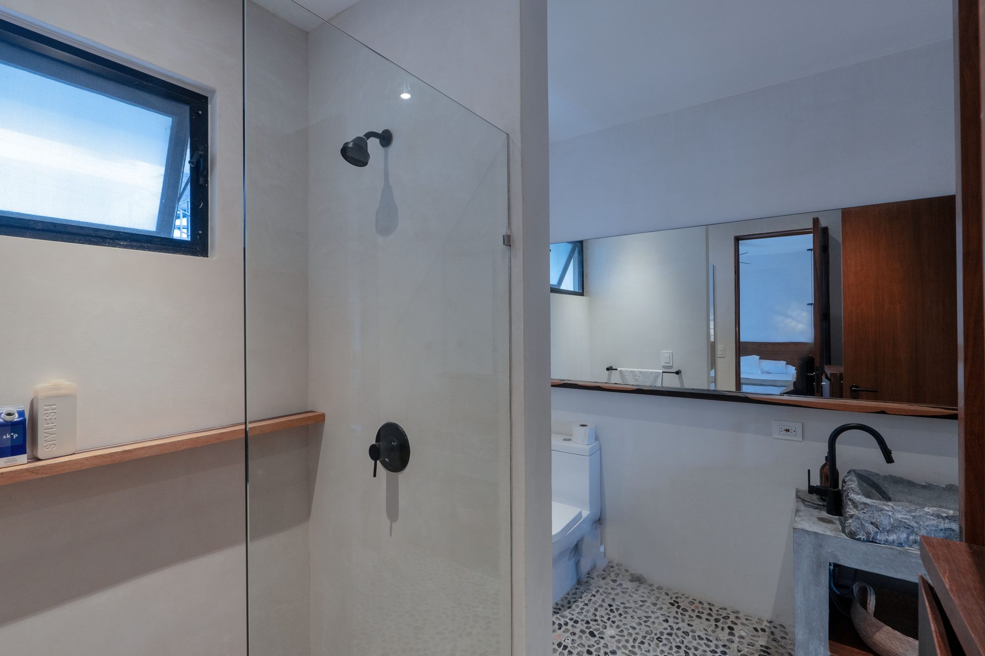 Walk-in glass shower with a black rain shower head