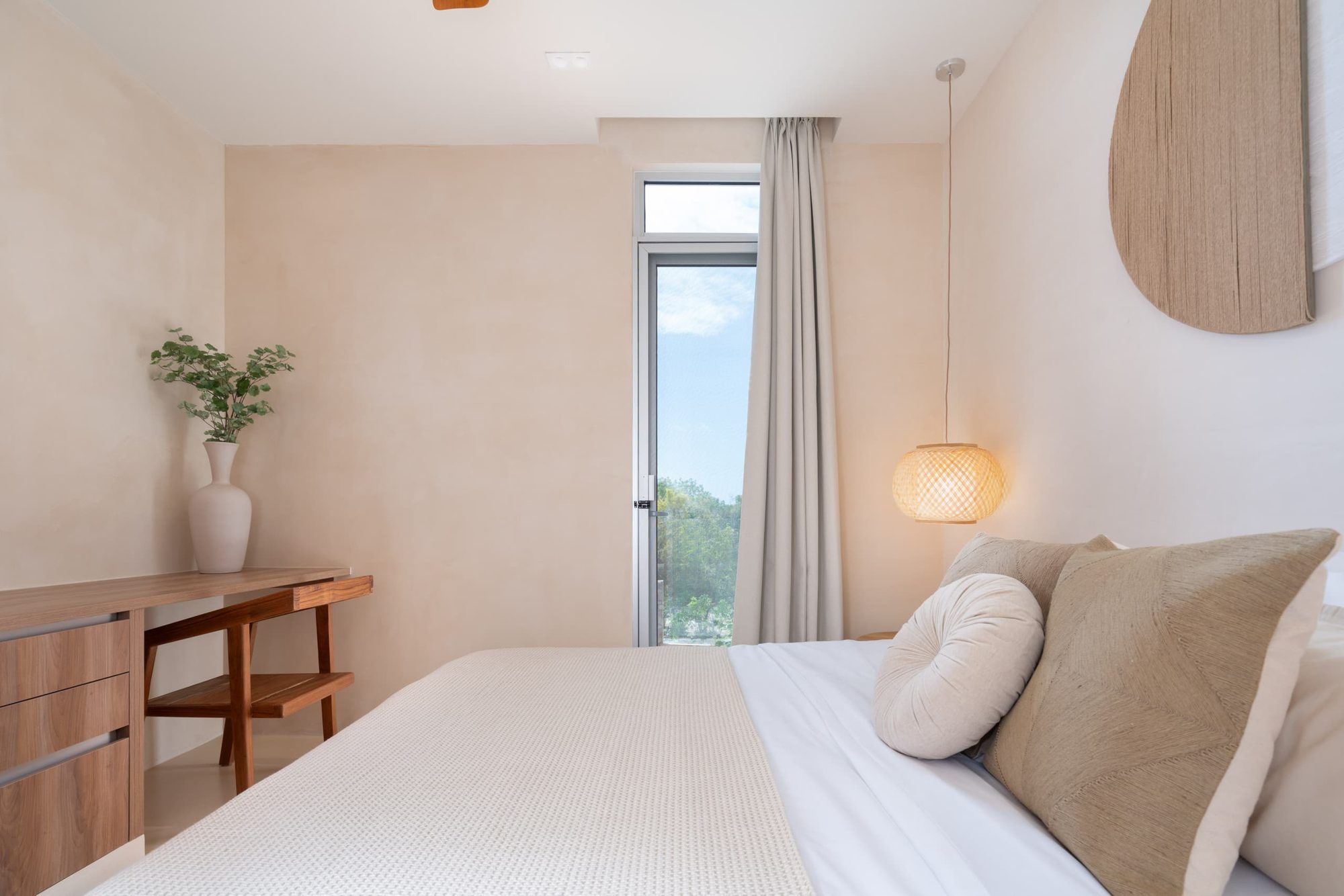 Bedroom with a king bed, wood dresser and tall window