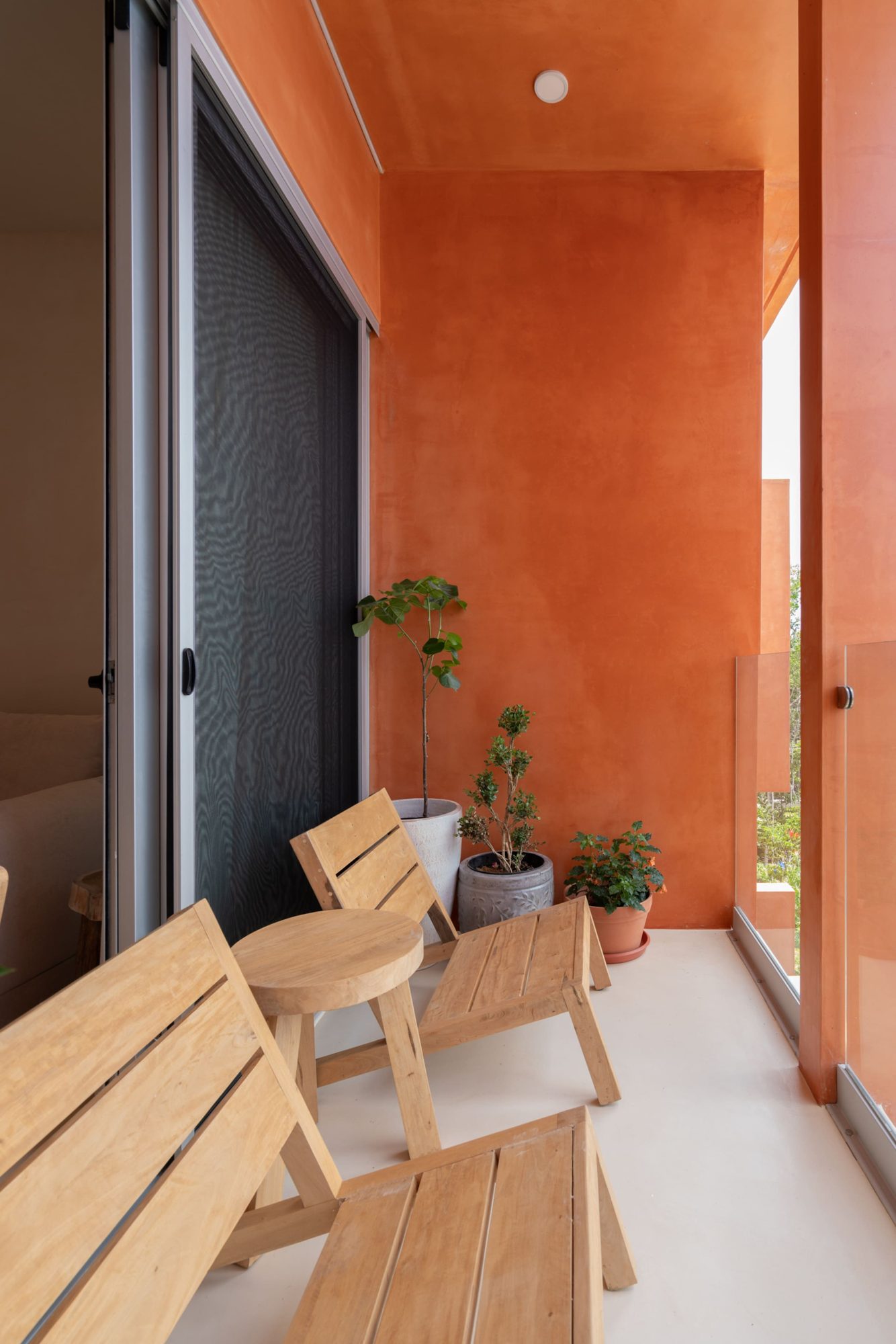 Balcony with wooden chairs and potted plants