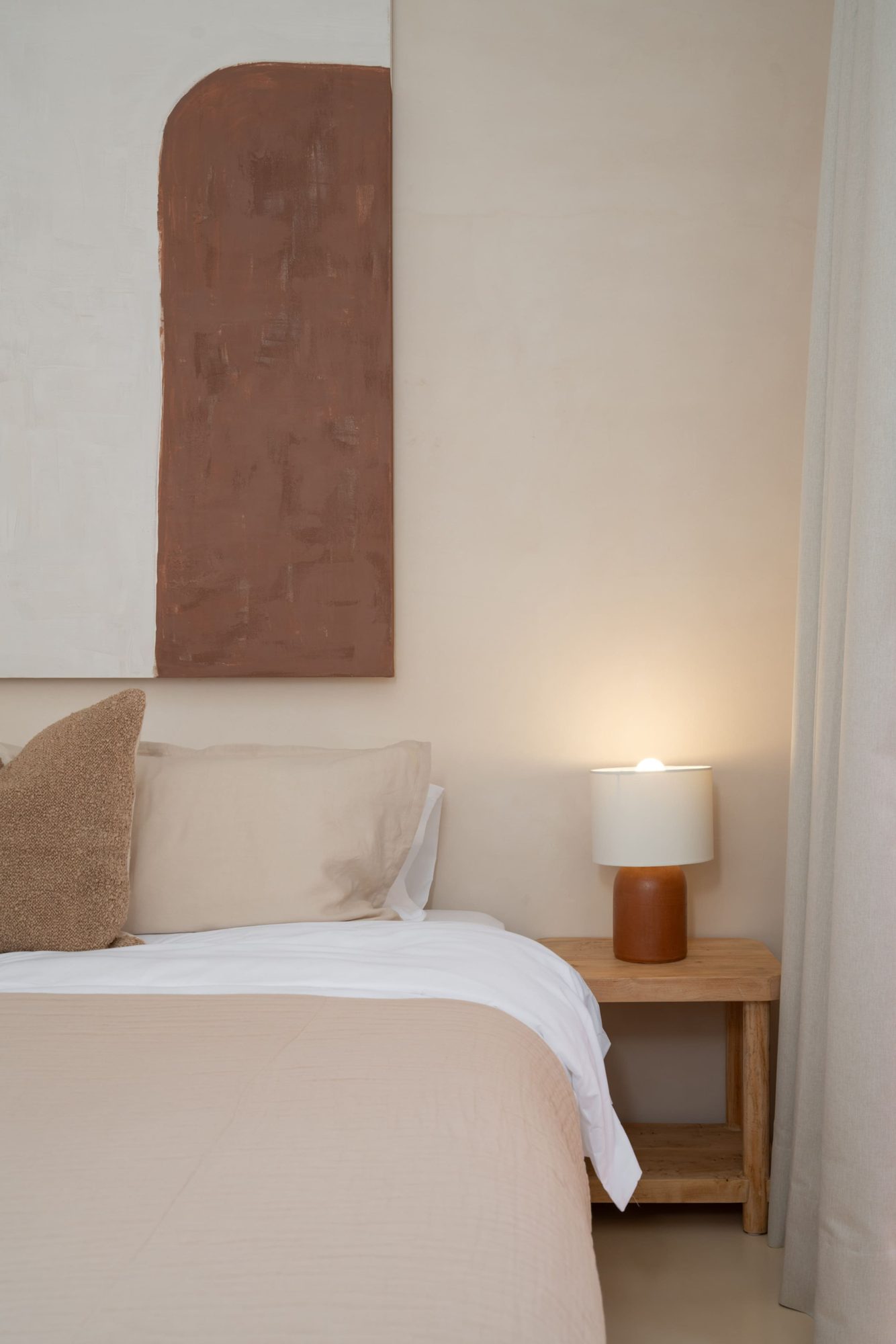Bedside table and lamp beside the king bed