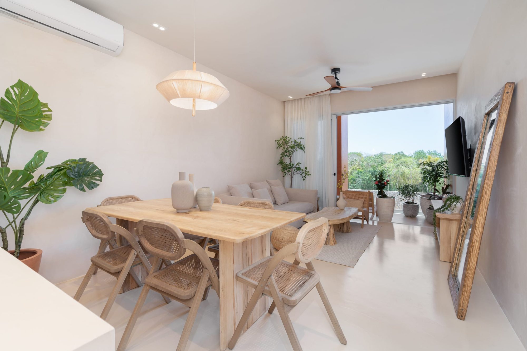 Dining area with rattan chairs and the living room beyond