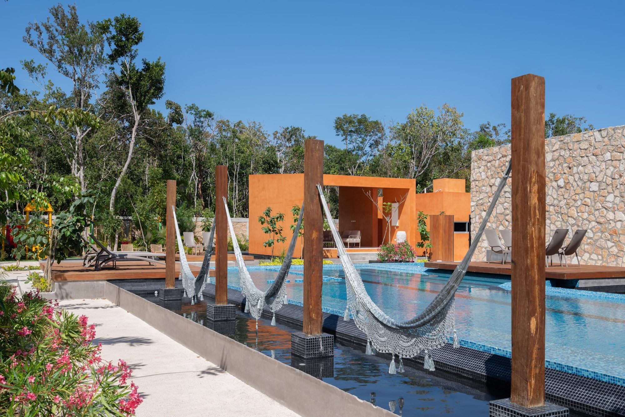 Hammocks strung over the pool between wooden posts