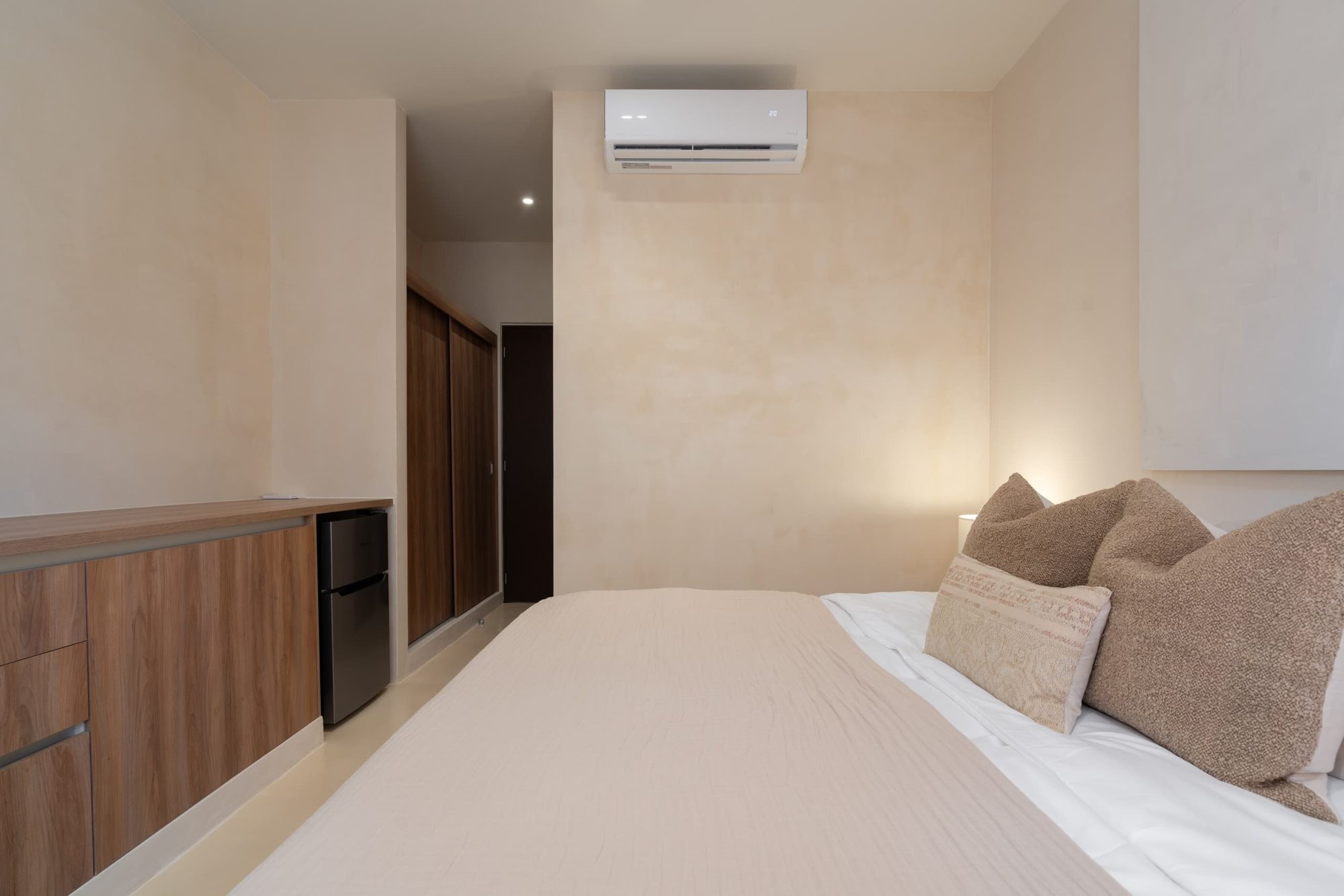 Bedroom with a long wood dresser and air conditioning